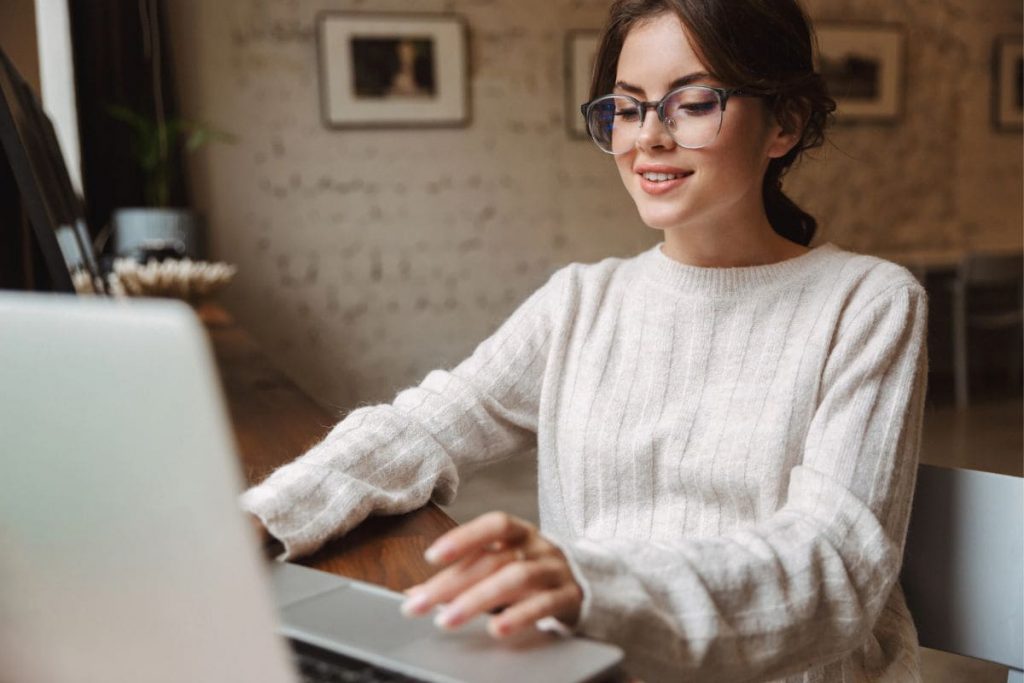 A woman working remotely at her home office desk, using a laptop.