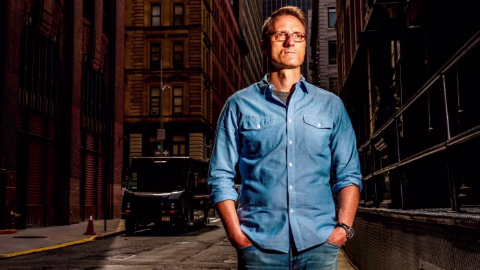 Activist behind Engine No. 1 Exxon campaign builds stake in Siemens Energy Charlie Penner stands with his hands in his pockets on a city street, wearing glasses and a blue shirt.