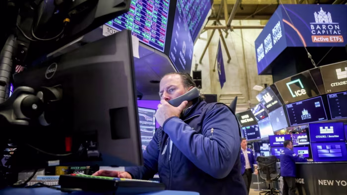 Andersen Group valued at $1.75bn in IPO for consulting spin-off of Enron auditor A trader on the New York Stock Exchange floor talks on the phone while monitoring multiple screens with financial data.