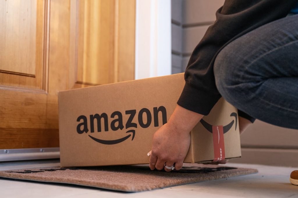 Could Amazon Help You Become a Millionaire? Delivery person putting down Amazon box at doorstep.