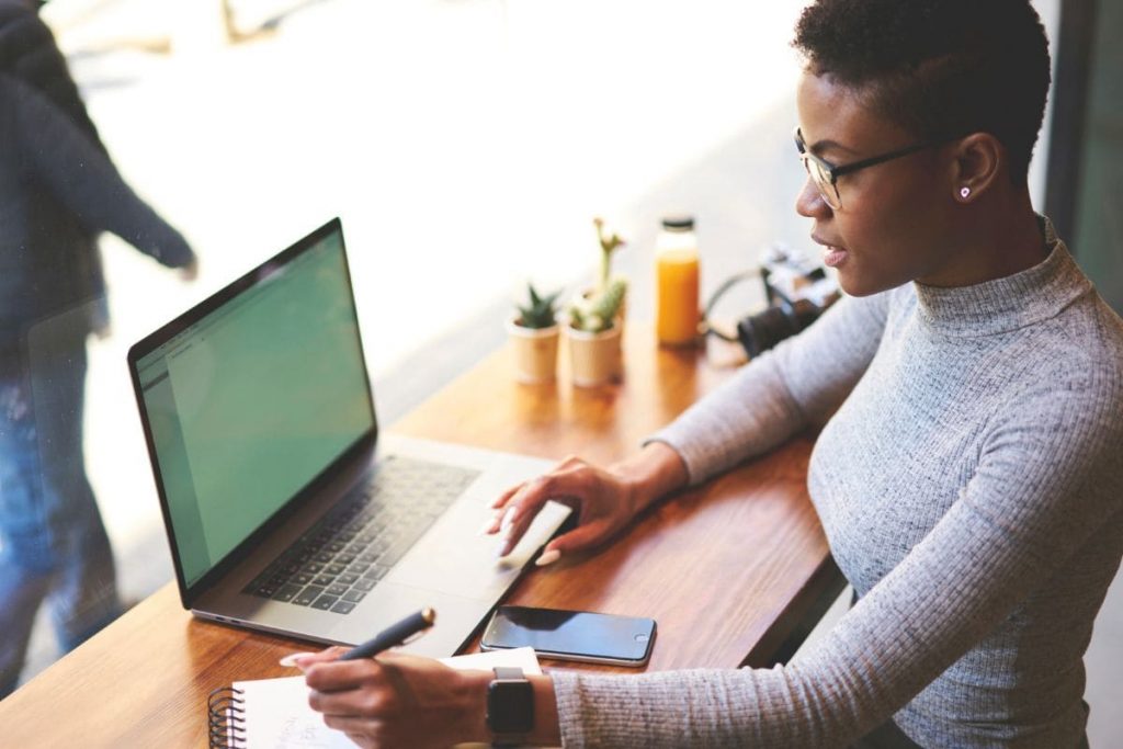 How to Market Your Business on Facebook: 11 Effective Ideas A woman working on her laptop in a cafe.