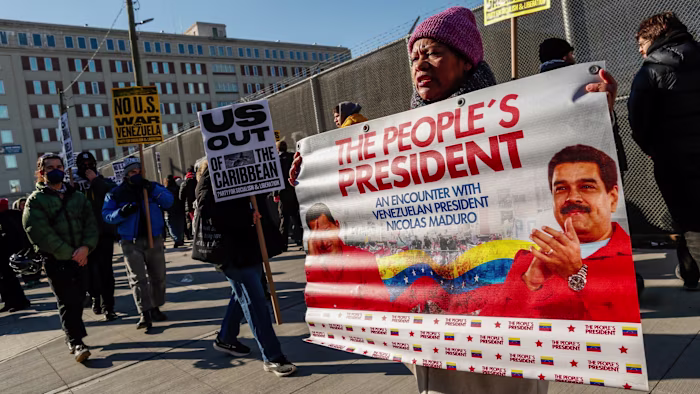 US legal case against Maduro to test limits of presidential power Demonstrators hold signs opposing US intervention in Venezuela, including a large banner with Nicolas Maduro’s image and the text ‘The People’s President’.