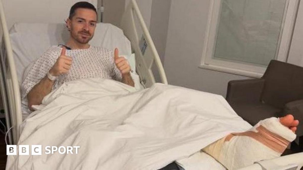 Midfielder Jack Grealish posing in a hospital bed with a bandaged foot