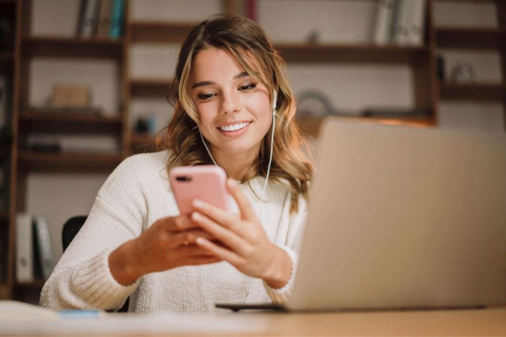 How to Create a Virtual Assistant Portfolio in 7 Easy Steps A virtual assistant working from home, using a laptop and phone.
